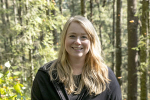 blonde white woman smiling in forest setting